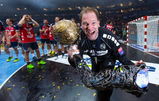Handball-Torhüter Mattias Andersson hält den Pokal in die Kamera und freut sich.